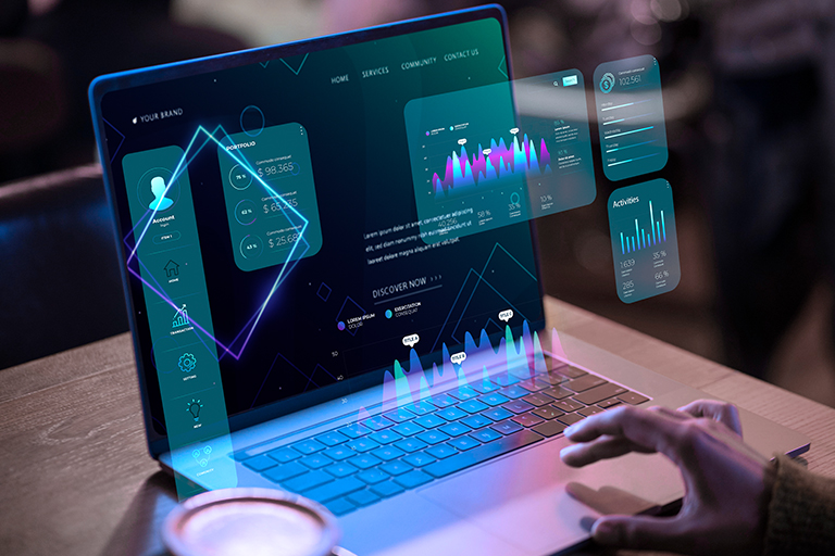 A person using a laptop with futuristic holographic market data charts, graphs, and interface elements projected above the keyboard, suggesting advanced technology or market analysis. A coffee cup is on the table nearby.
