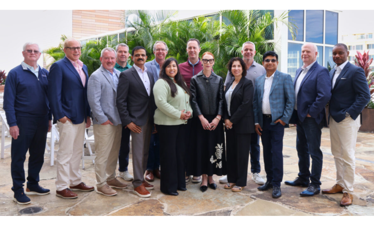 A group of thirteen people, dressed in business or business-casual attire, smile and pose together outdoors as the 2026 Officers and Board of Directors for TechServe Alliance, with palm trees and modern buildings in the background.