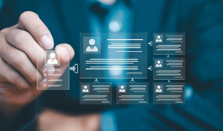 A person in a suit selects a digital profile icon on a transparent screen displaying multiple user profile cards and data, symbolizing AI-powered candidates in online networking or digital human resource management.
