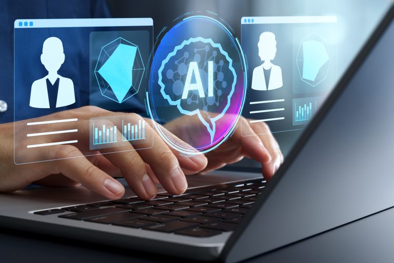 Hands typing on a laptop keyboard with virtual graphics showing AI, user profiles, data charts, and geometric shapes, symbolizing how AI investments are shaping digital technology concepts for recruiters.