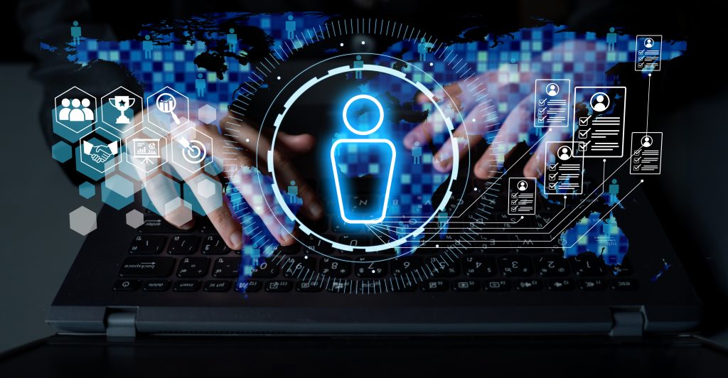 30% of the Week Back: What US Agencies Are Really Doing With AI 1 Hands typing on a laptop keyboard with digital icons overlaid, including a large user avatar, hexagons, and technological interface elements, suggesting themes of digital identity, AI integration, and cybersecurity.